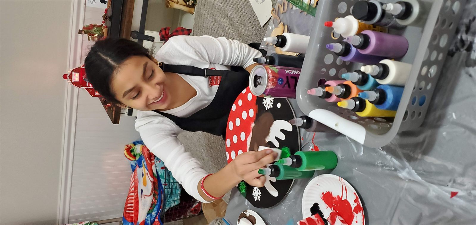 Smiling guest painting a holiday reindeer sign