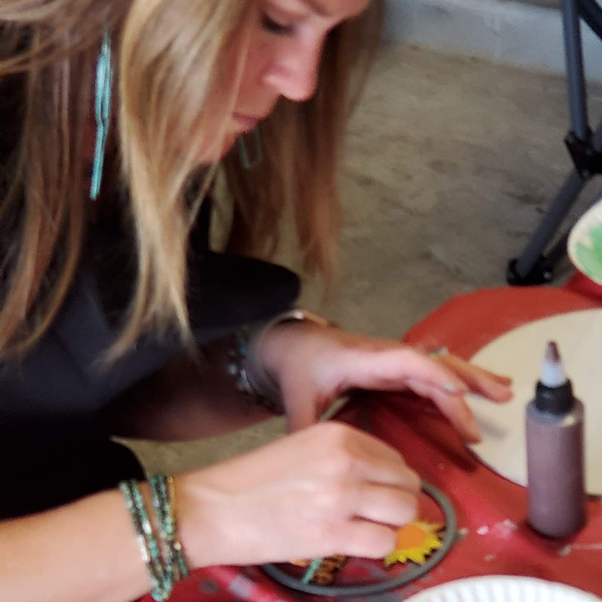 Woman painting at a SIS paint party with supplies