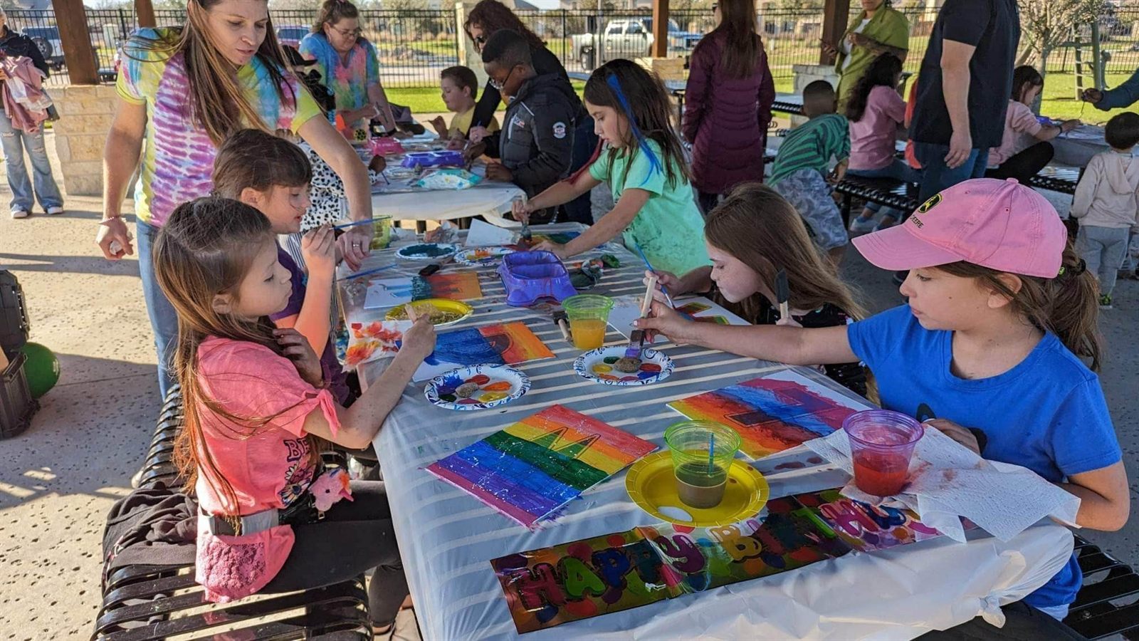 Kids painting together at an outdoor community group event